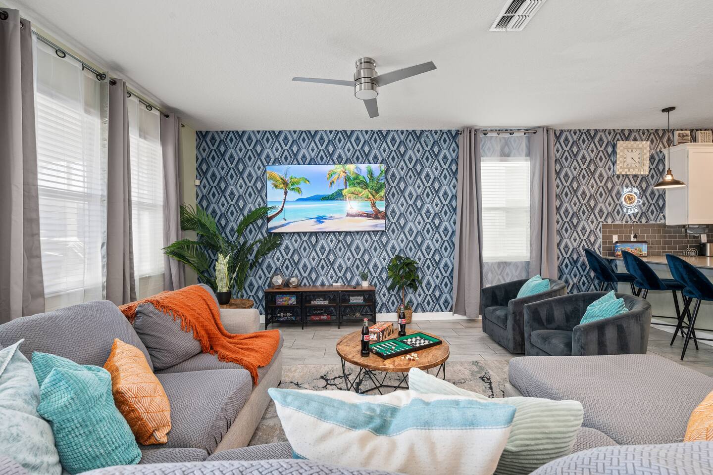 Open living room with plush seating, board games, and breakfast bar beyond