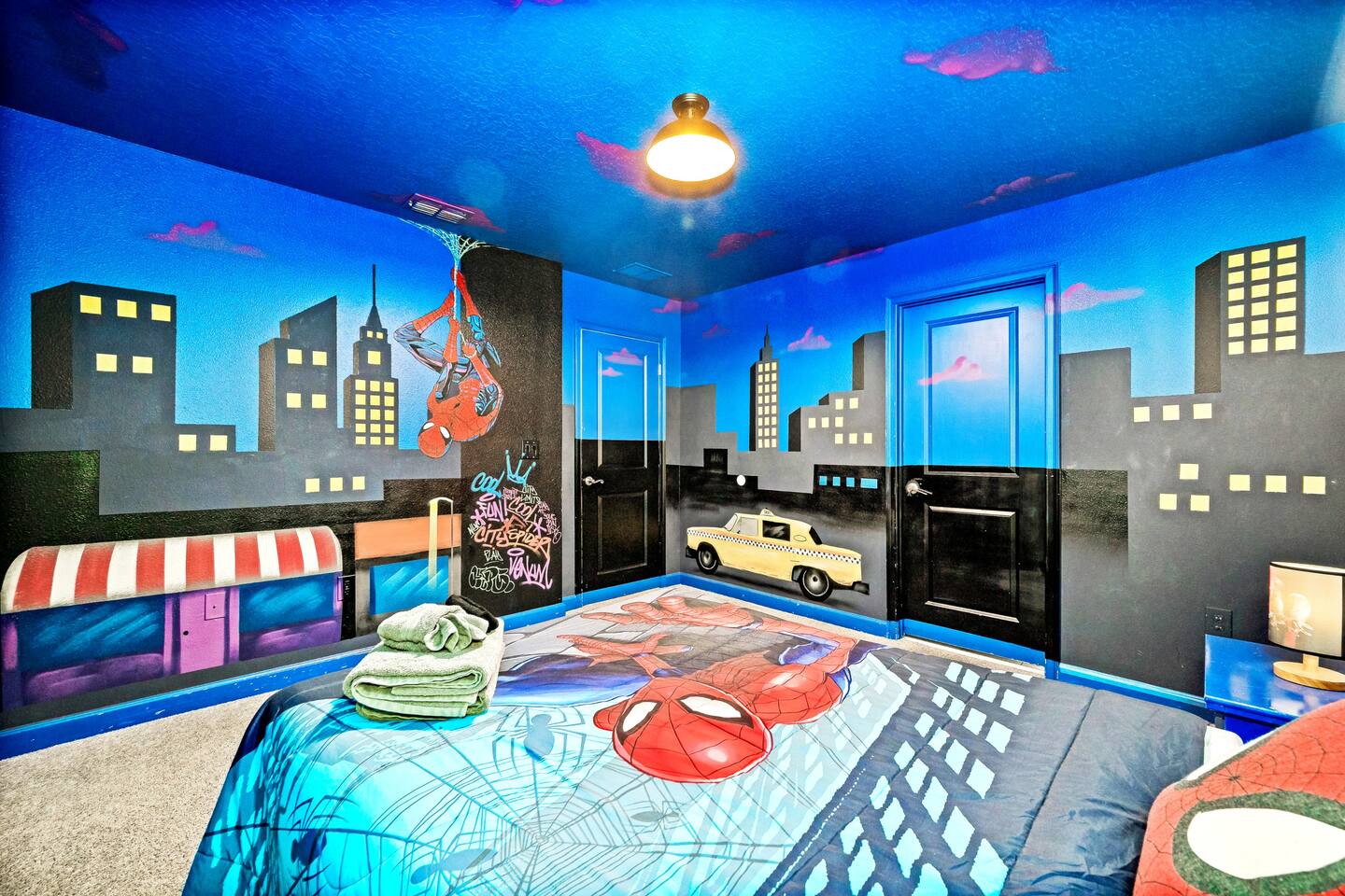 Spider-Man room's wraparound cityscape mural with hanging Spidey painted above t