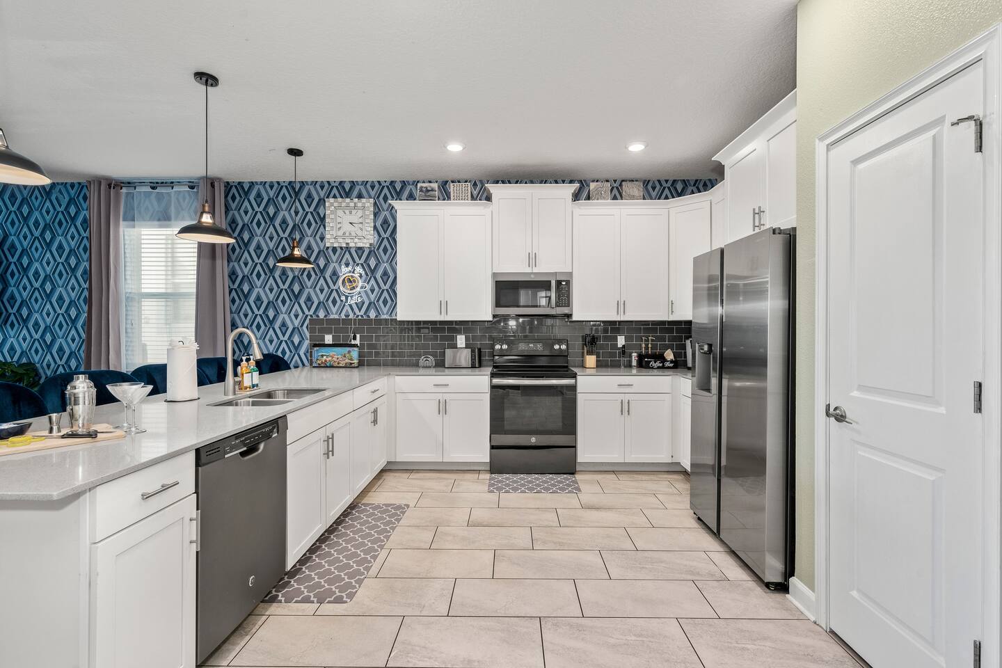 Fully equipped kitchen with stainless appliances, pantry, and coffee bar station