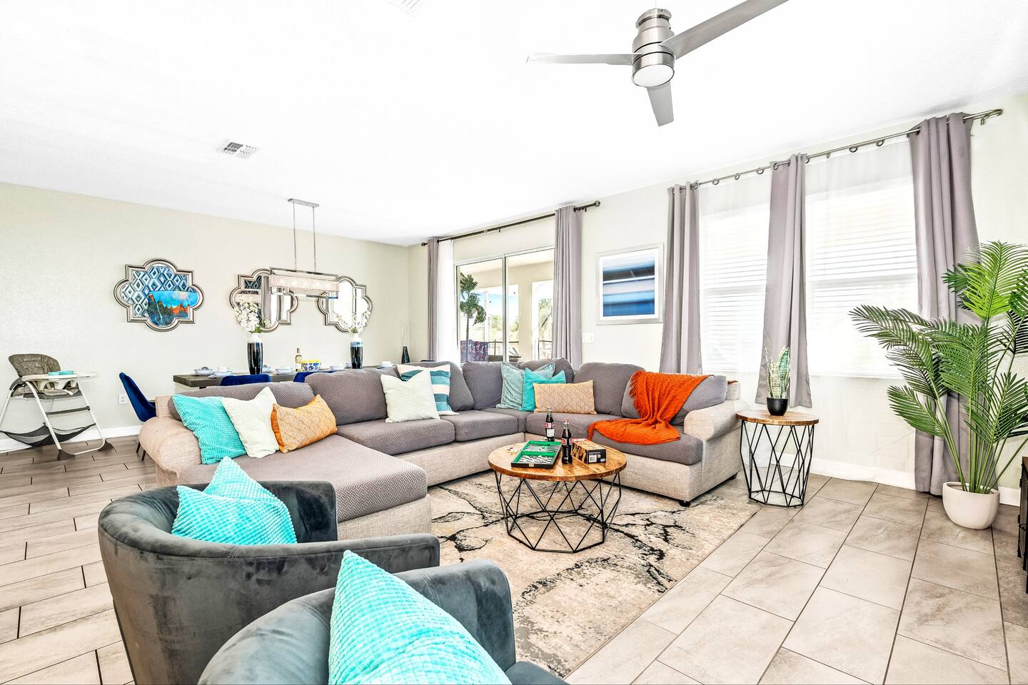Open-concept living and dining area with sectional, board games, and abundant na