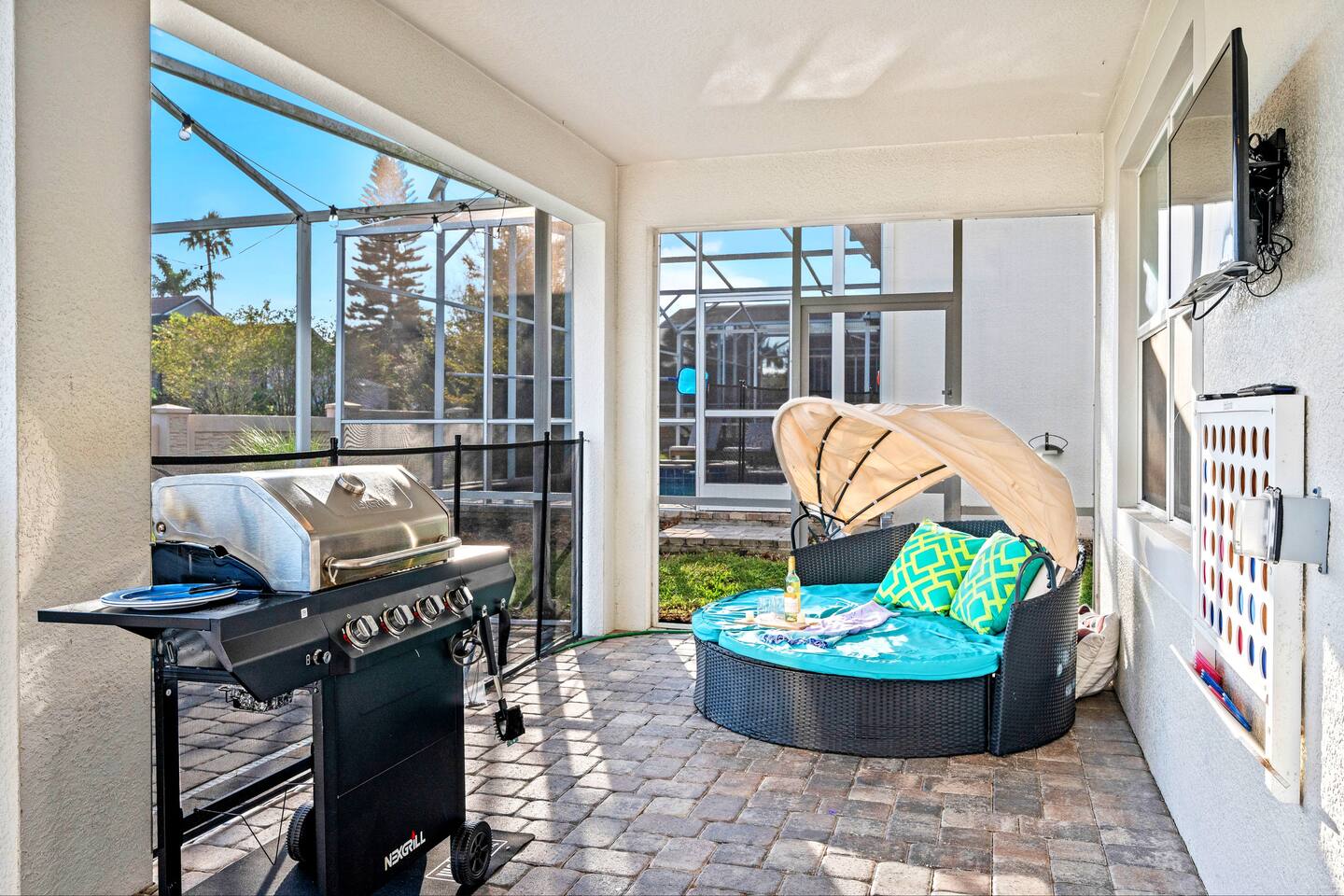 Covered lanai with gas grill, outdoor TV, canopy daybed, and life-size Connect F