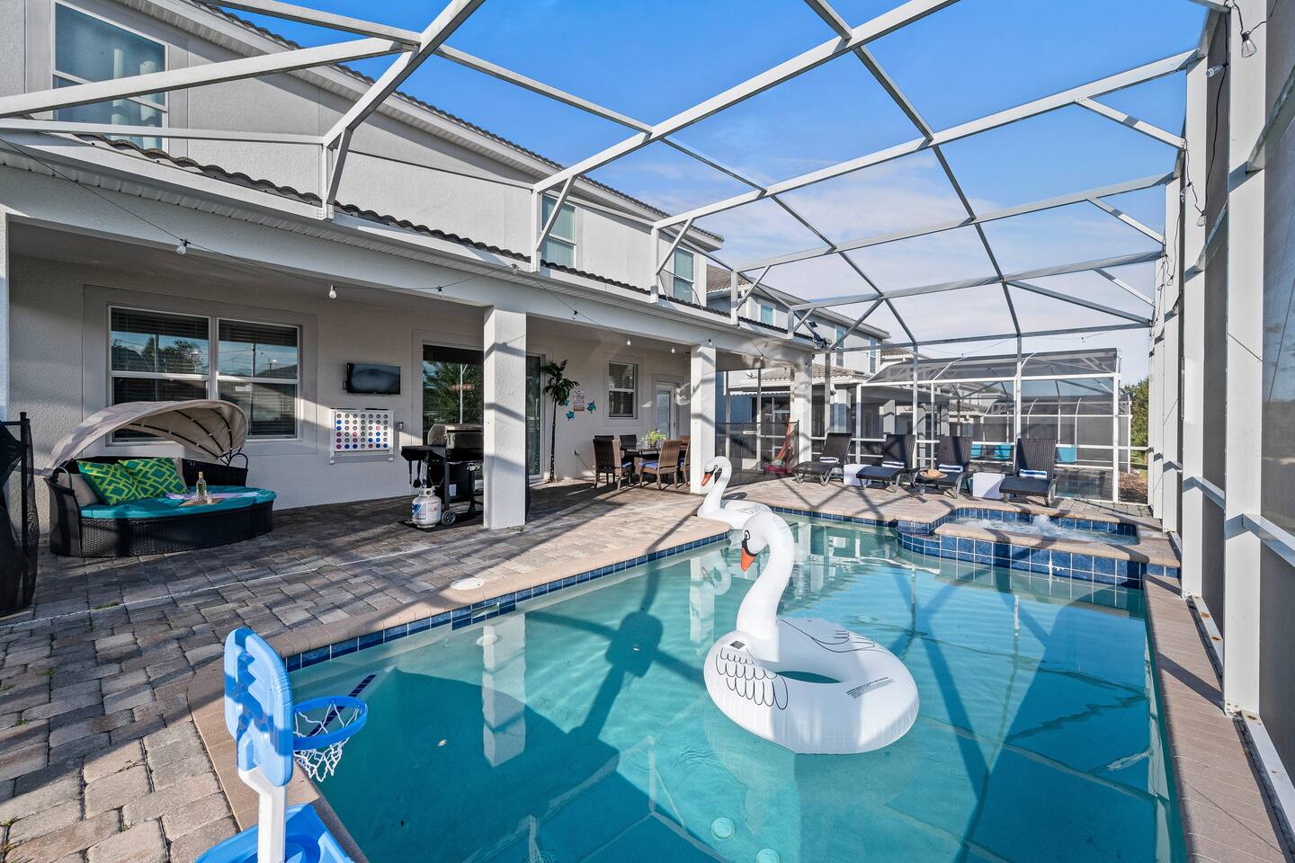 Pool with basketball hoop, spa, and covered lounge and grill area beyond
