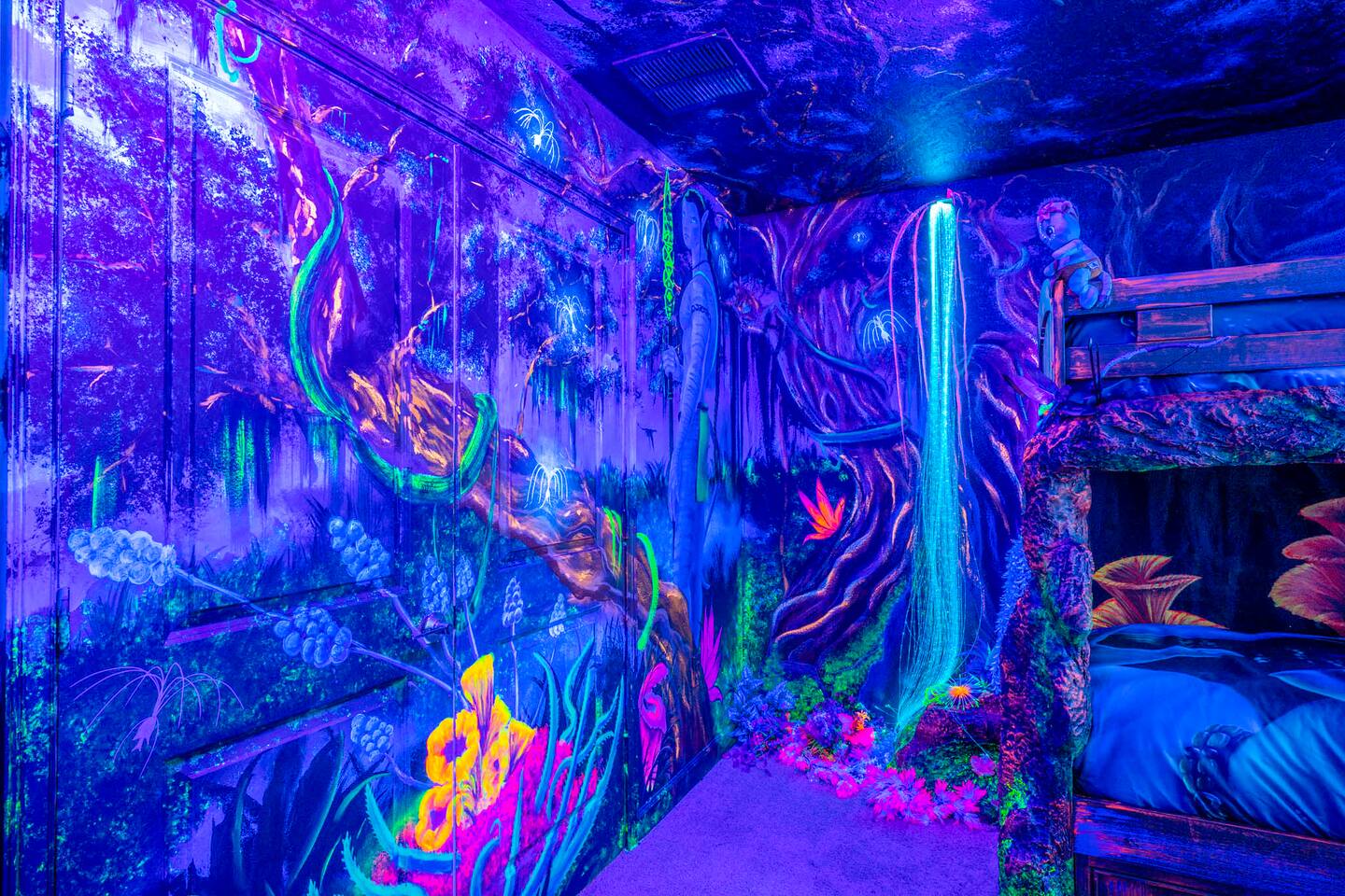 Avatar room under blacklight with fiber-optic waterfall and hand-painted glowing