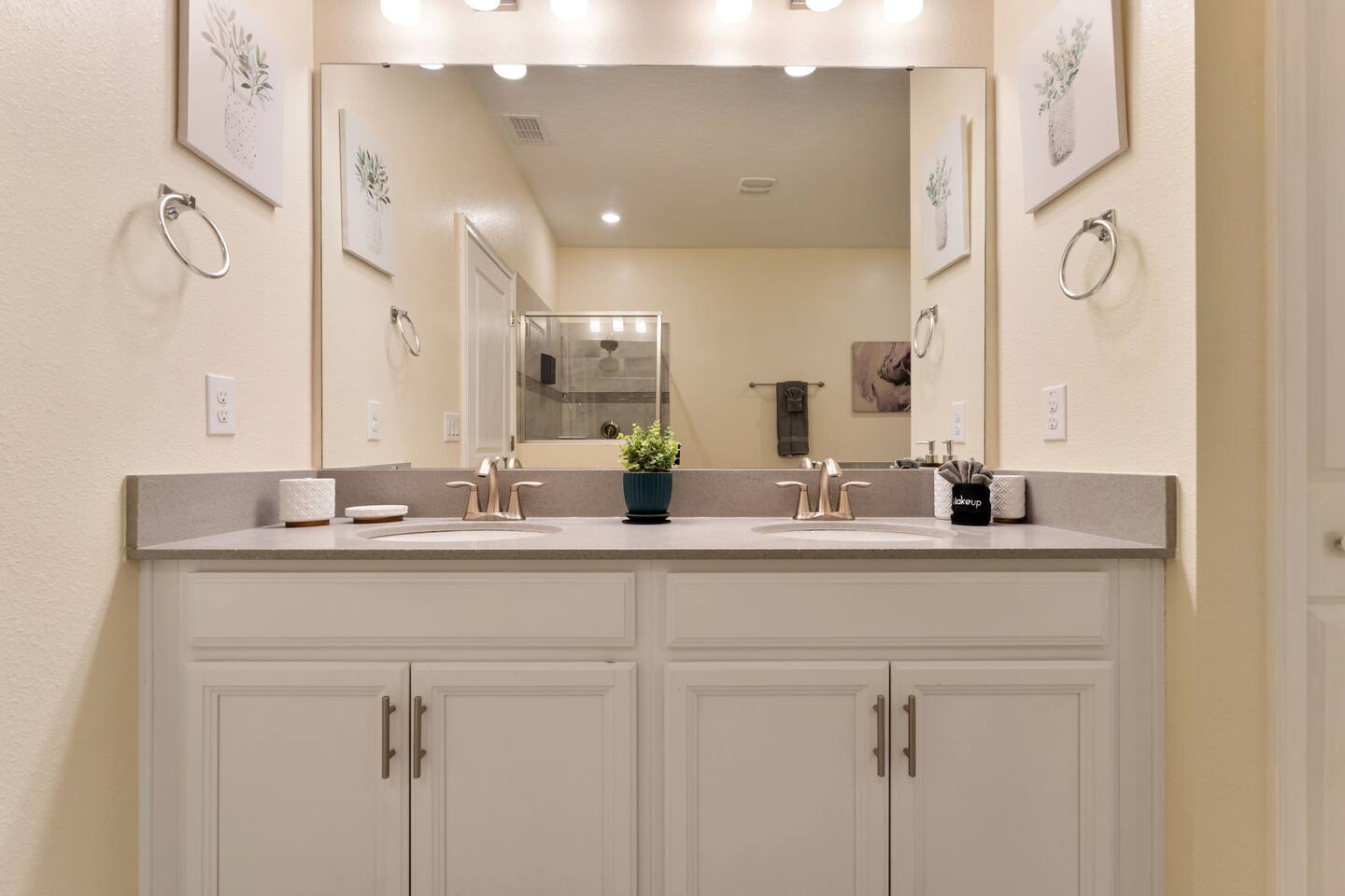 Double-sink vanity bathroom with large mirror and walk-in shower beyond