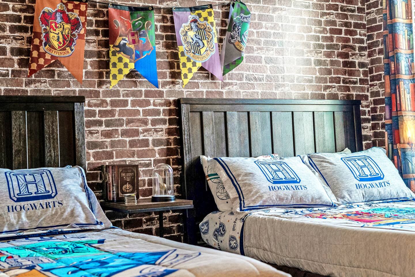 House-crest banners hang above the wizard room's headboards and potion-book nigh