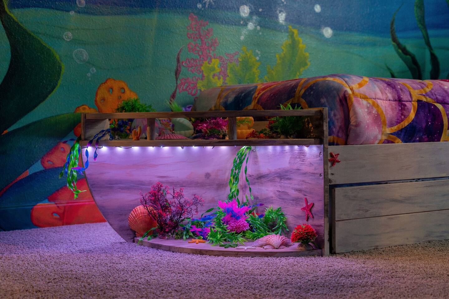 Boat-style bed with a lighted under-bed reef scene and seashell accents