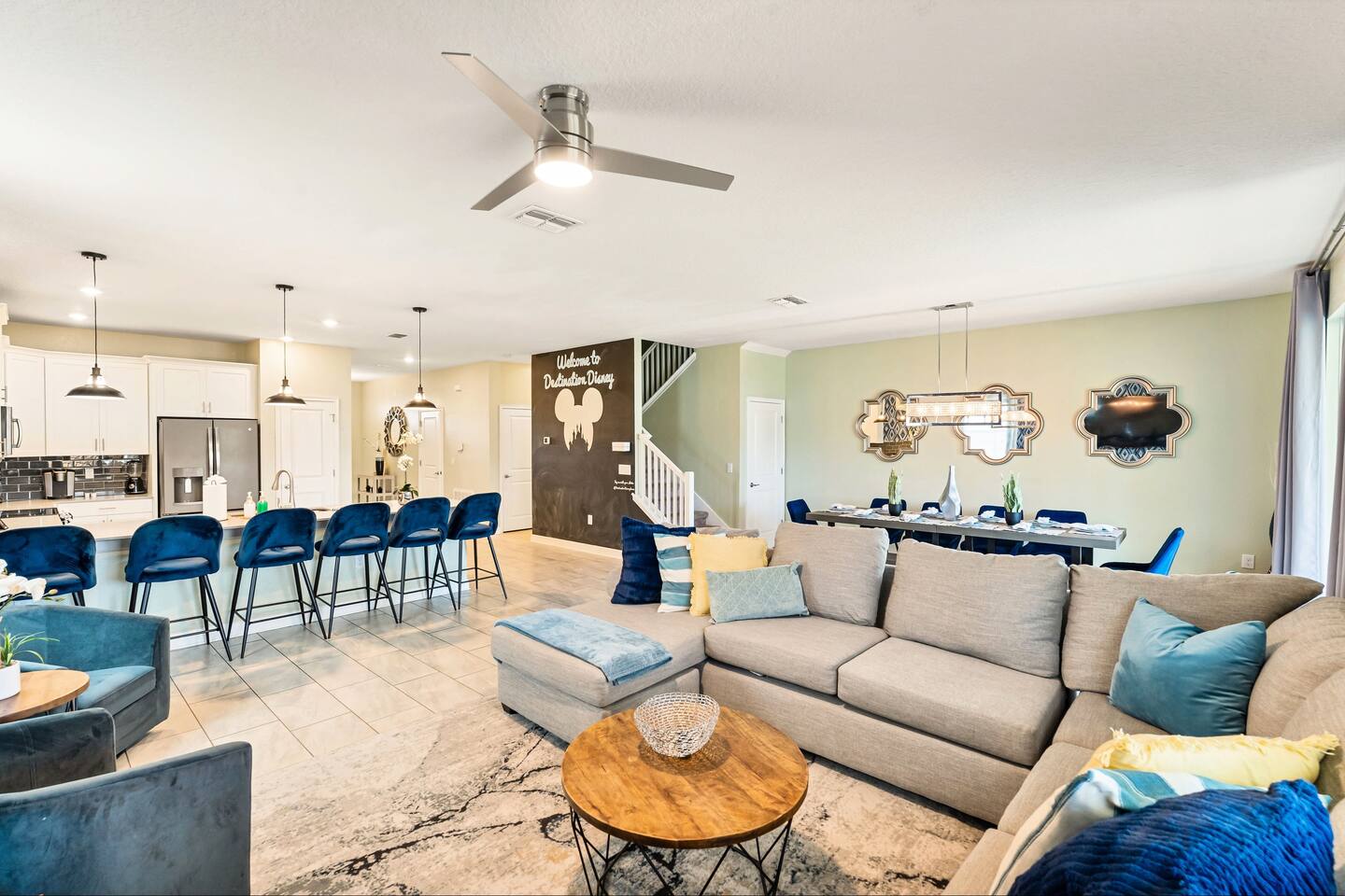 Open-concept great room connecting the sectional lounge, dining area, and breakf