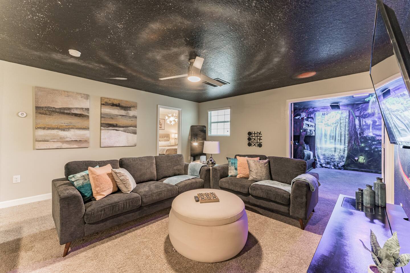 Galaxy-ceiling loft lounge with plush seating outside the themed bedrooms