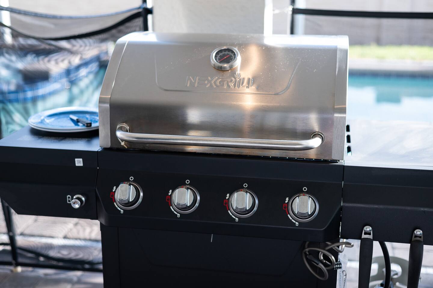 Gas grill at the covered outdoor kitchen beside the pool