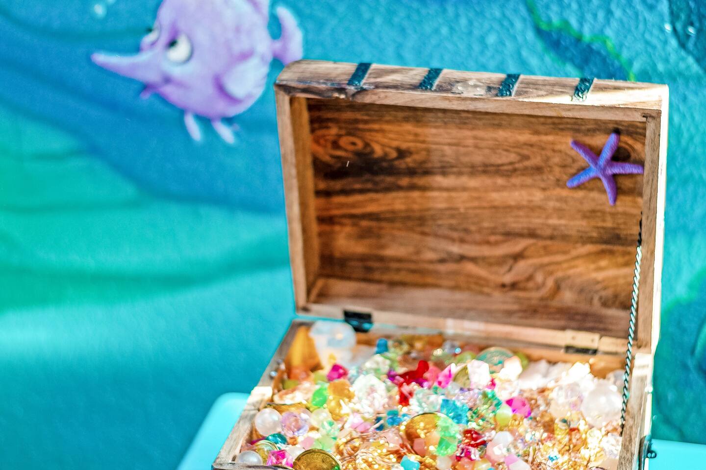 Treasure chest of gems beneath the under-the-sea mural in the Ariel room