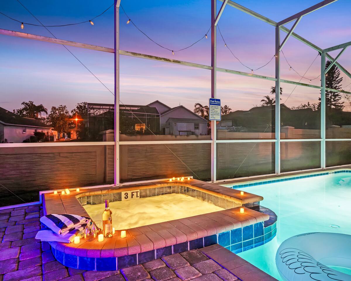 Candlelit spa bubbling beside the pool at dusk