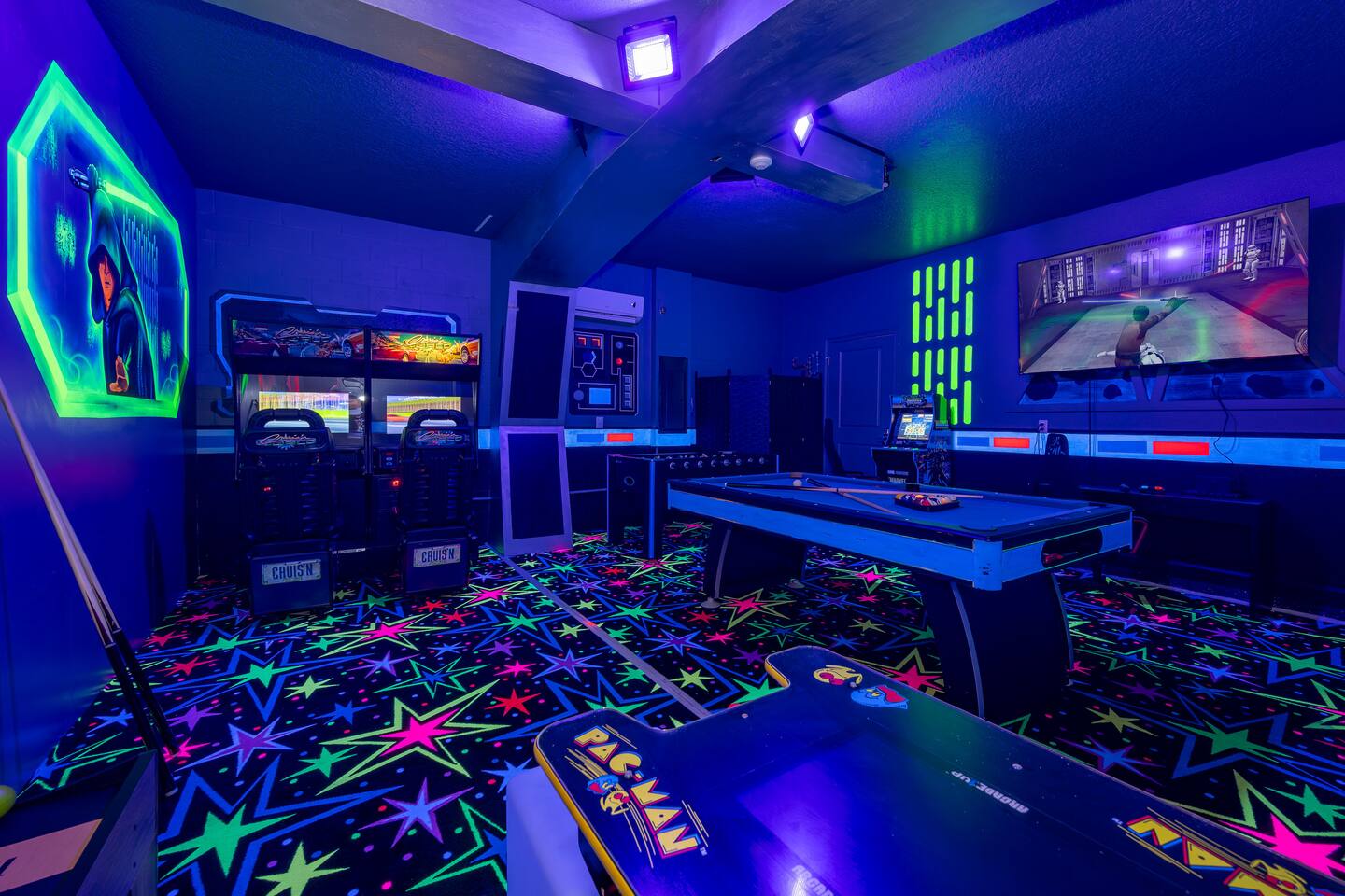 Racing simulators, Pac-Man cabinet, and air hockey in the arcade room