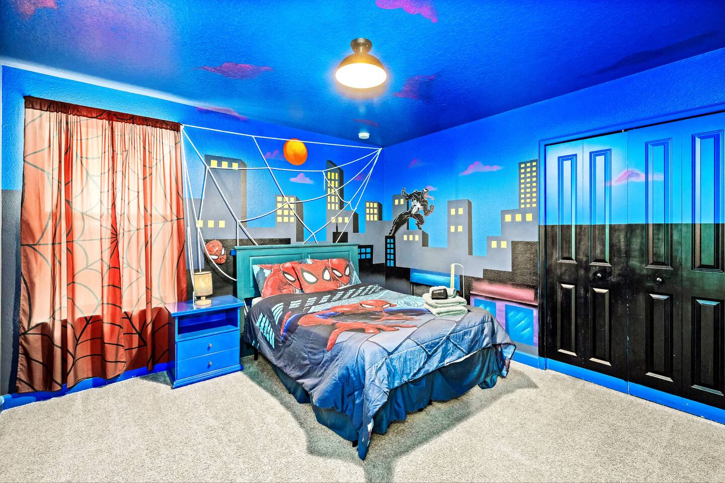 Spider-Man bedroom with full-wall skyline mural, themed bedding, and double clos