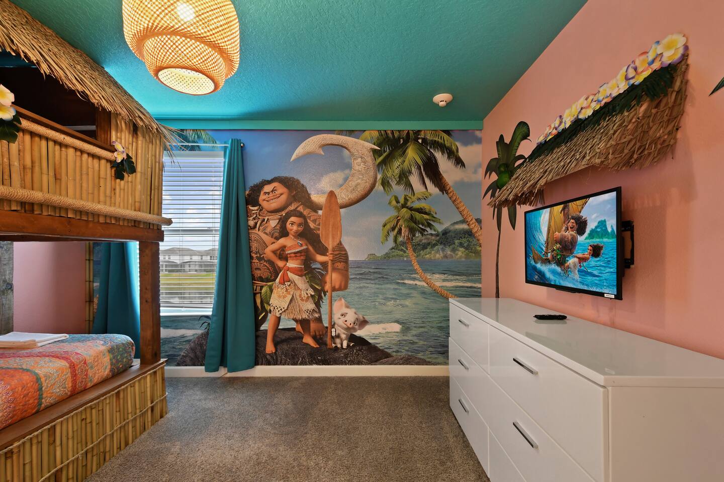 Moana beach mural with wall-mounted TV and dresser