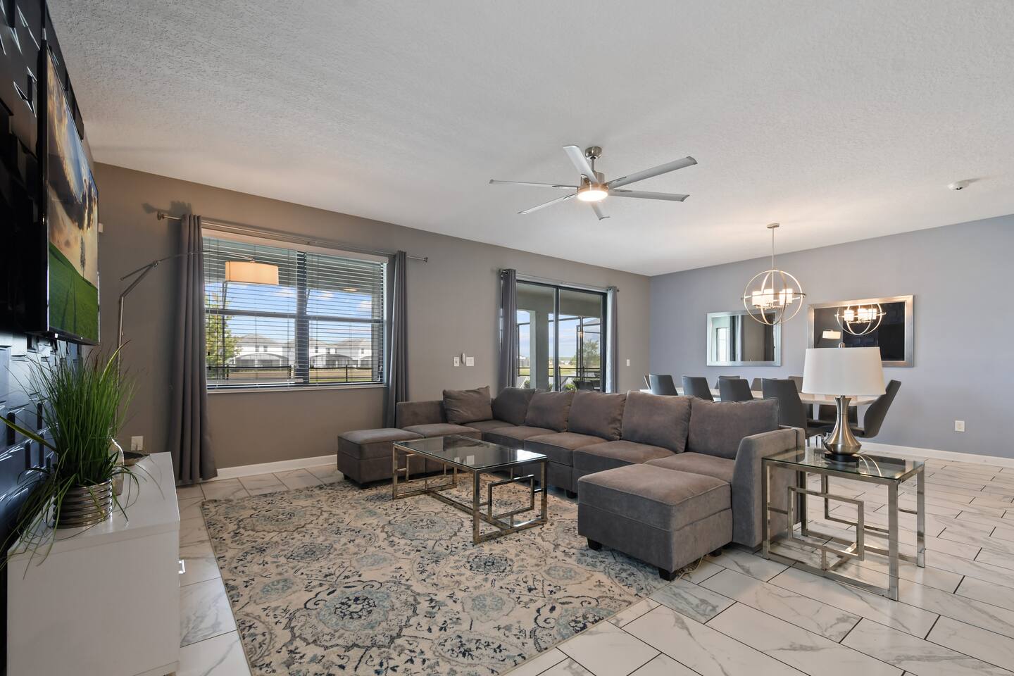 Living room with large sectional, TV, and dining area beyond