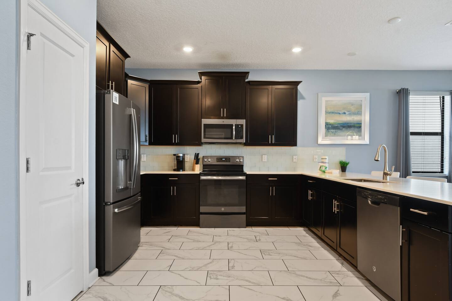 Full kitchen with stainless appliances and dark wood cabinets