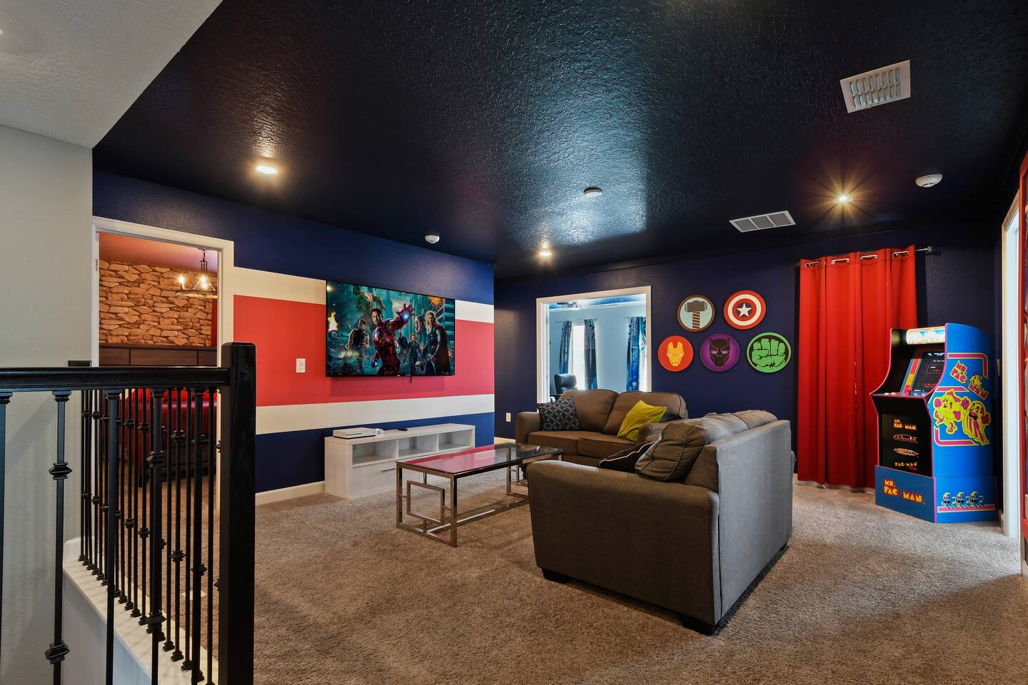 Avengers loft game room with TV, sofas, and arcade cabinet