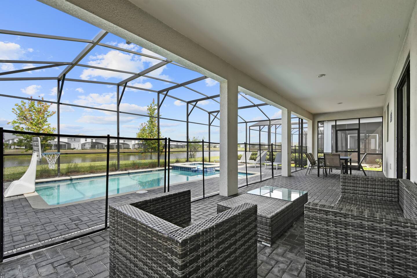 Screened lanai with lounge seating overlooking the private pool and lake