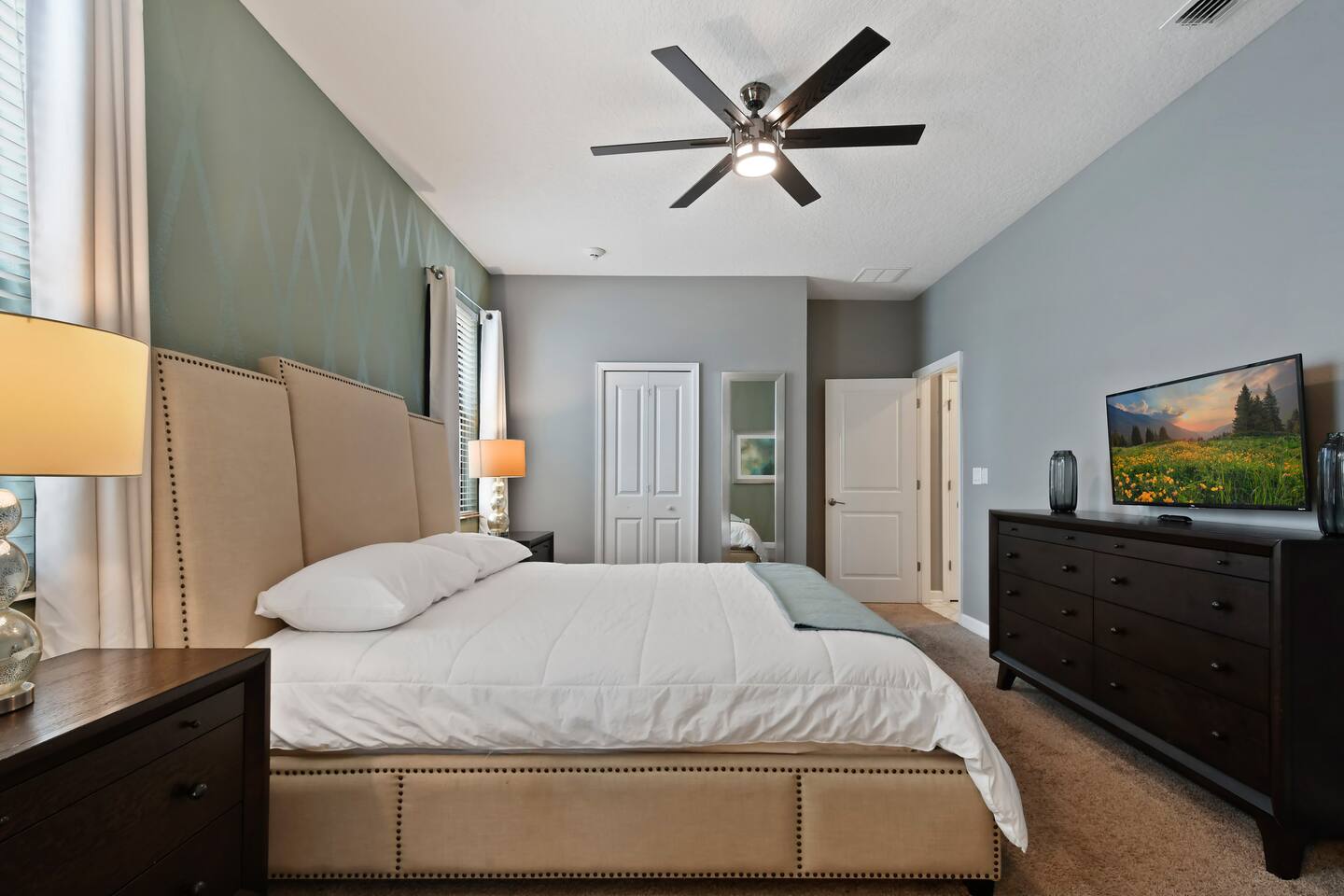 King bedroom with dresser, flat-screen TV, and closet