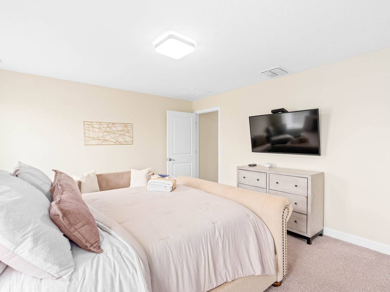 Relax in a bright, stylish retreat with plush bedding and a sleek TV!