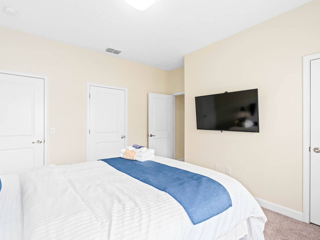 Tranquil retreat with plush bedding and wall-mounted TV for ultimate relaxation!