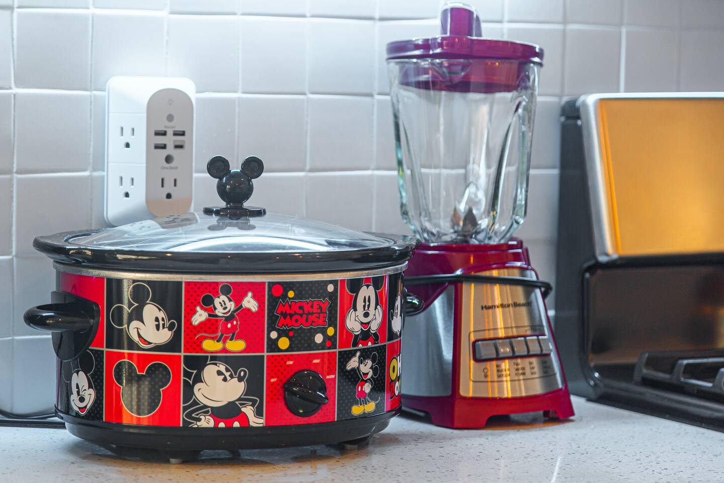 Mickey Mouse-themed slow cooker and blender on the kitchen counter.