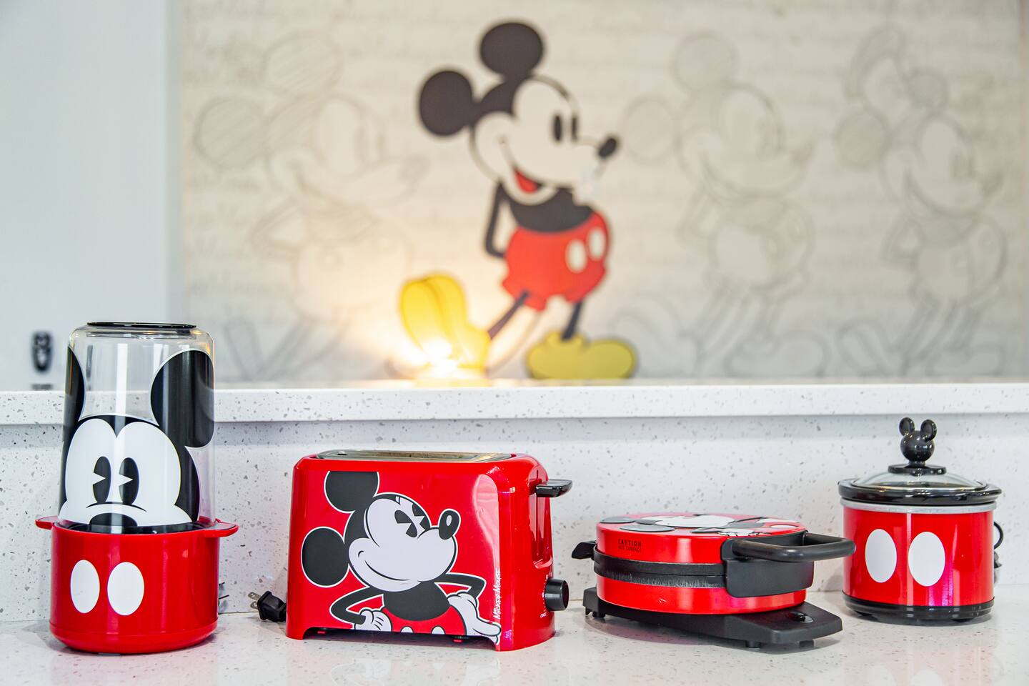 Mickey Mouse-themed small appliances arranged below a Mickey wall mural.