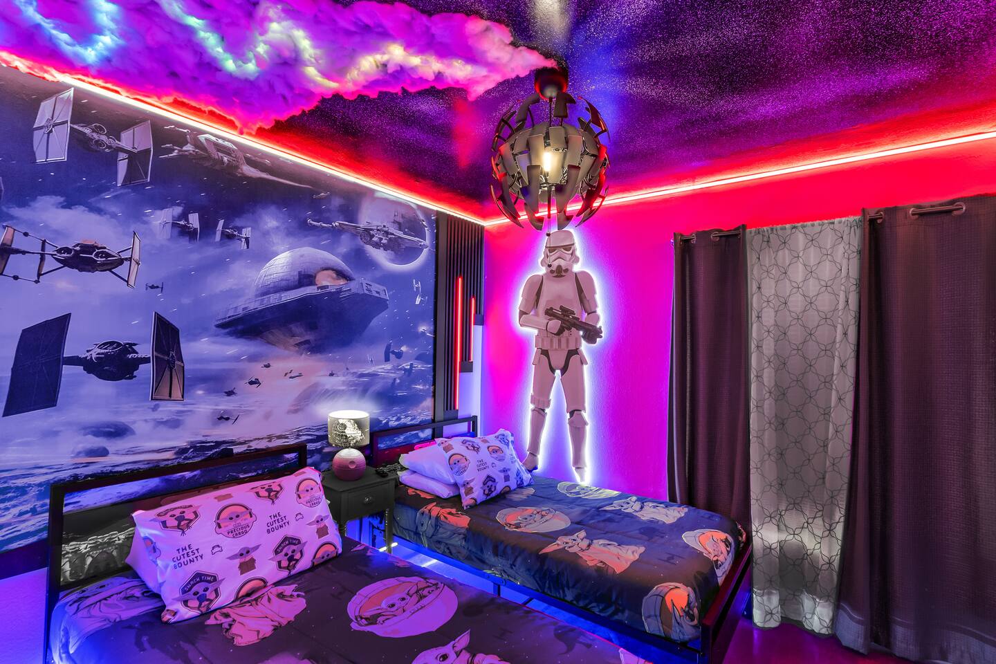Star Wars-themed bedroom with two twin beds, a stormtrooper figure, and a galaxy