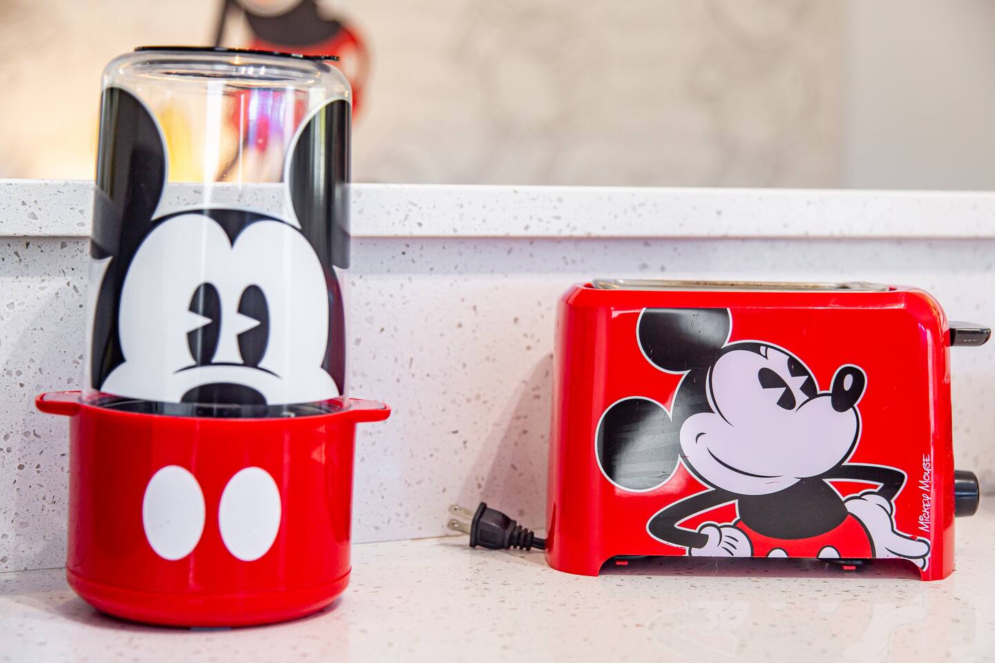Mickey Mouse popcorn maker and toaster on a kitchen counter.
