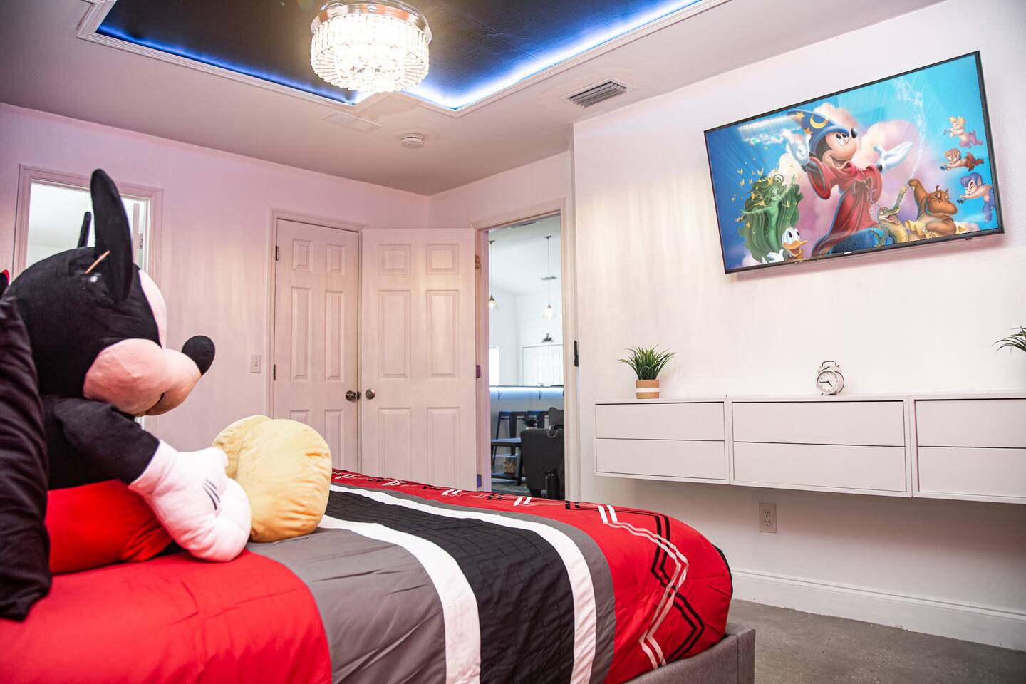 Mickey master bedroom with a wall-mounted TV and a floating dresser.