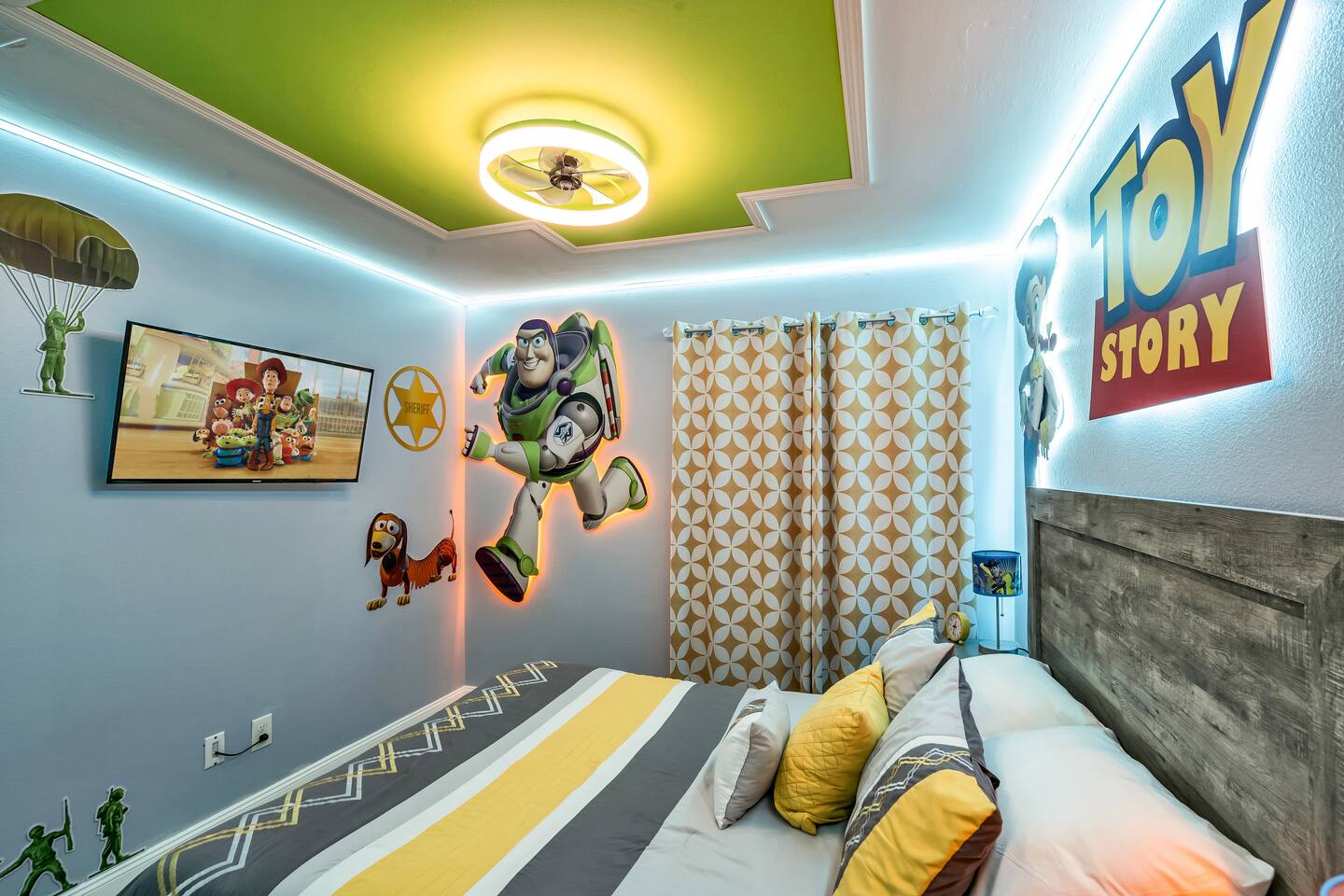 Toy Story bedroom with a queen bed, a Buzz Lightyear figure, and a green ceiling