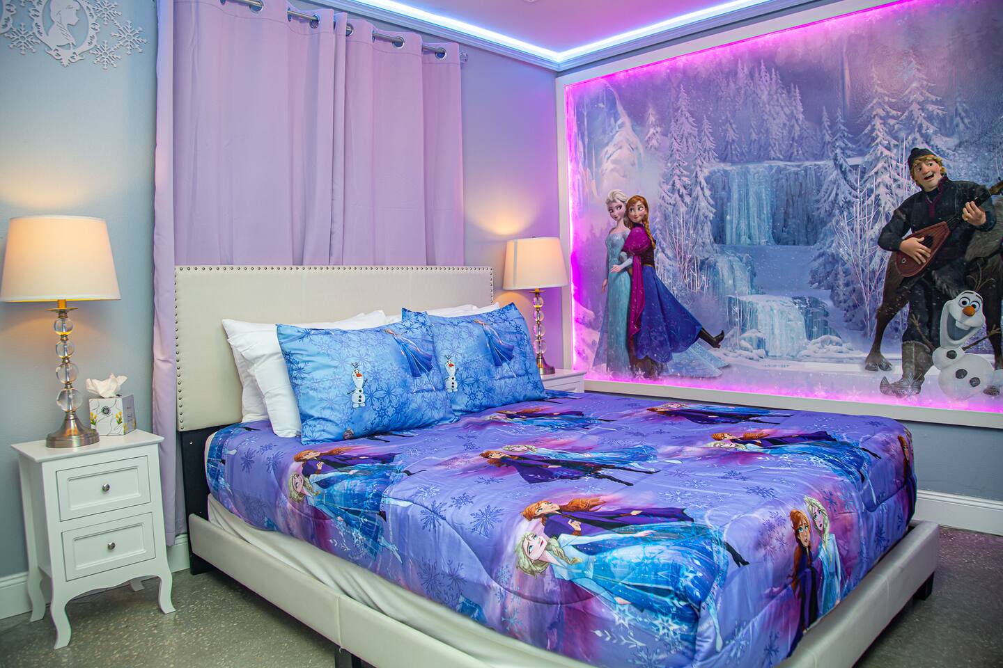 Frozen bedroom with a queen bed, matching lamps, and a character mural.