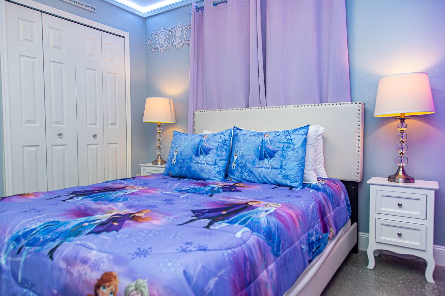Frozen bedroom queen bed with matching lamps and a closet.