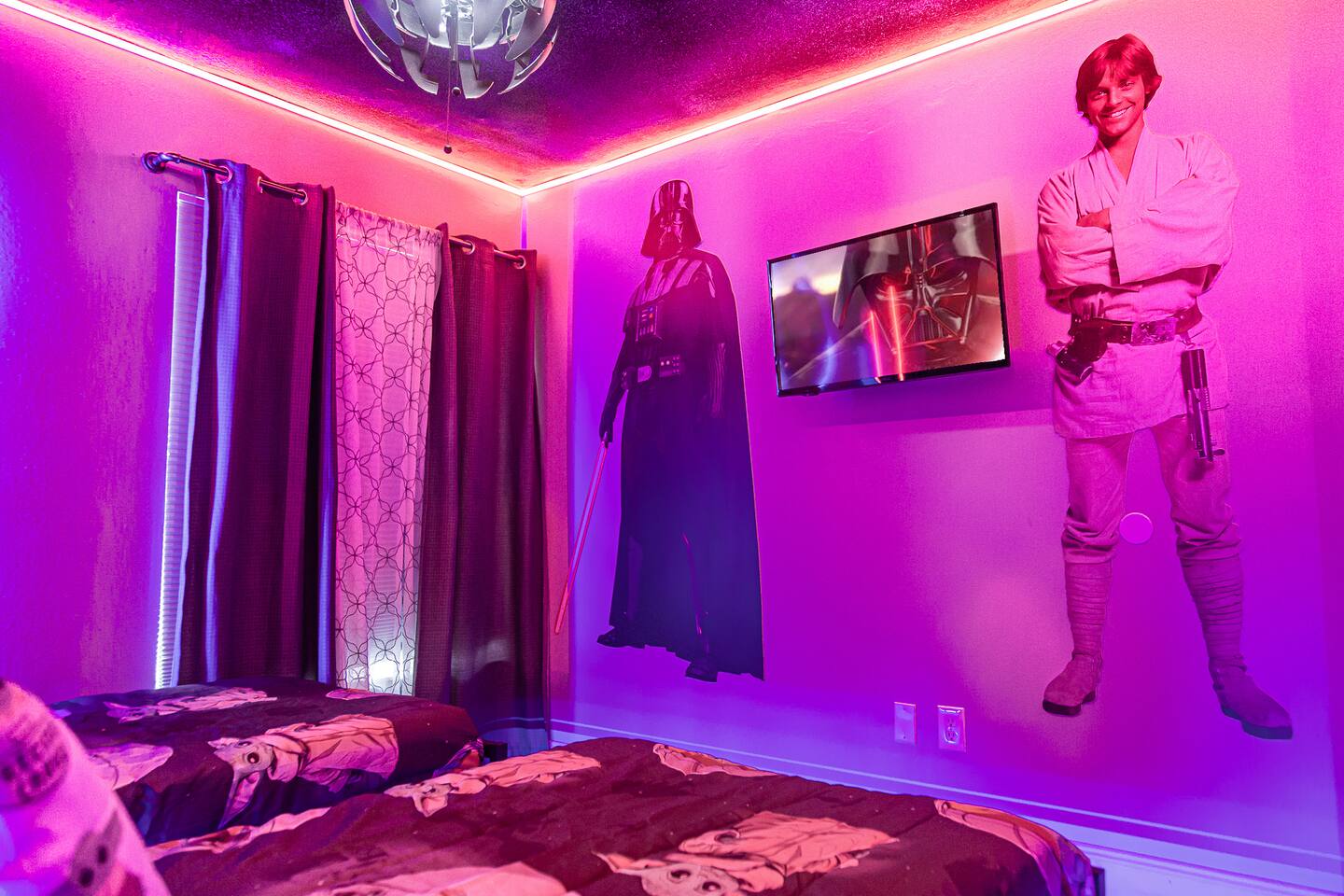 Star Wars bedroom with Darth Vader and Luke wall figures and a TV.