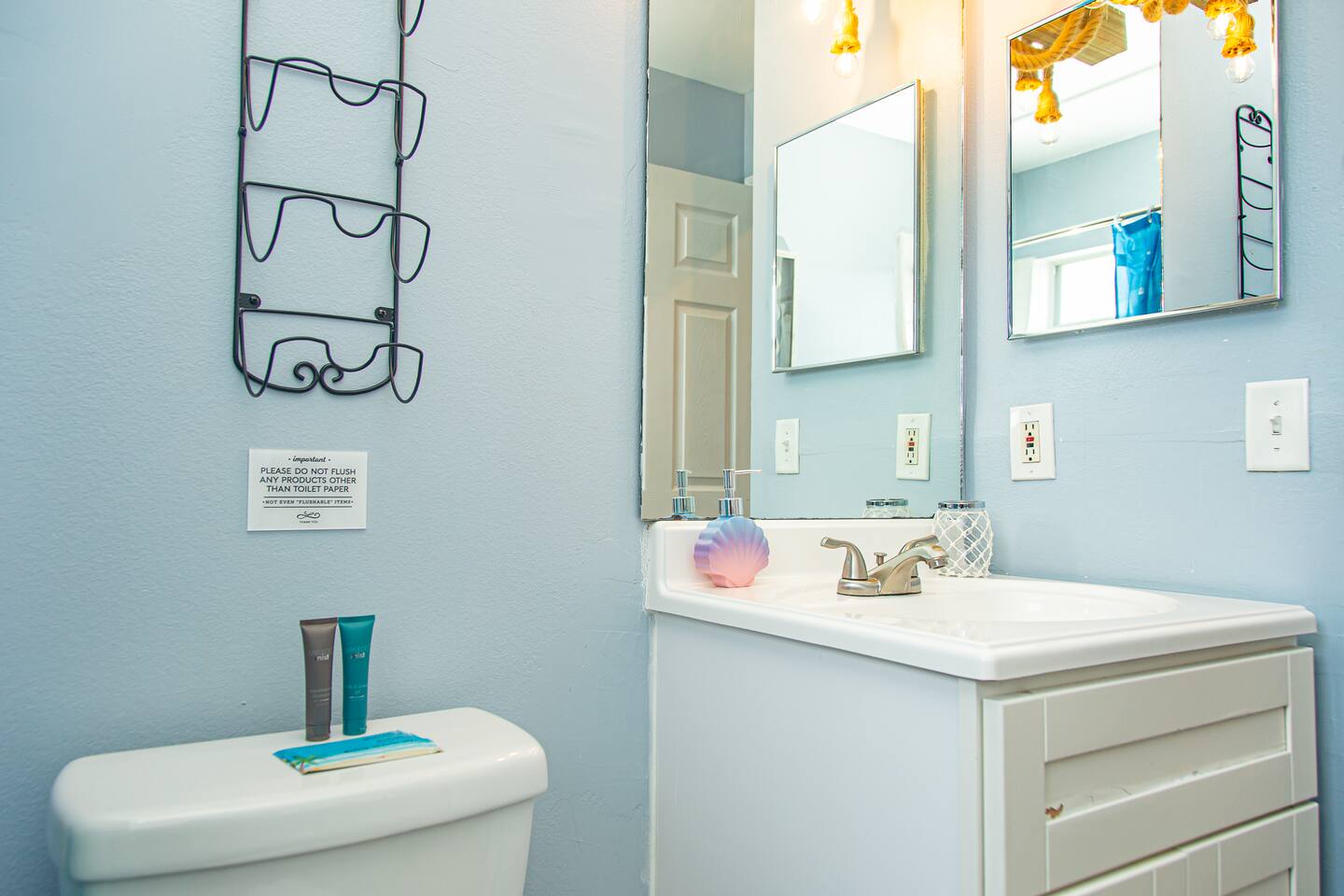 Little Mermaid-themed bathroom vanity with a mirror and a shell soap dispenser.