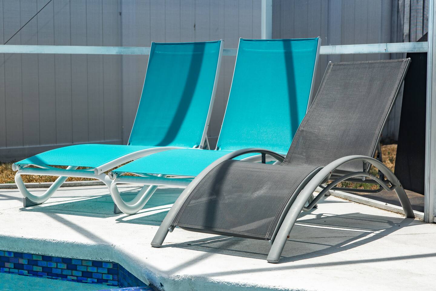Teal and gray lounge chairs on the pool deck.