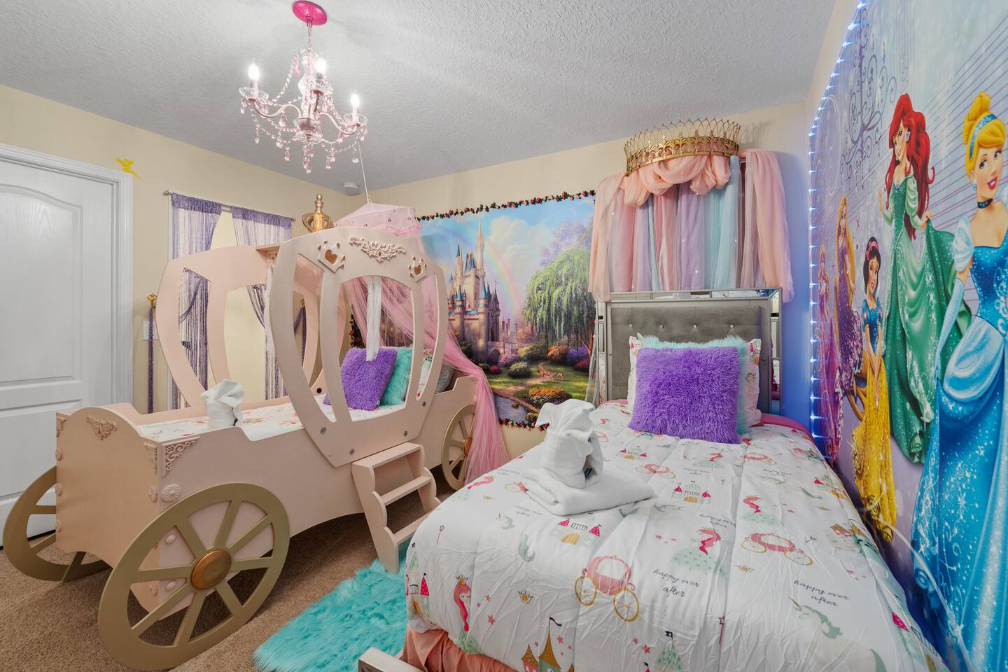 A pink princess carriage bed with canopy, chandelier and crown-topped twin bed.