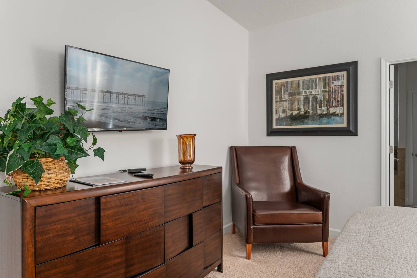 The king suite's dresser, wall-mounted TV and reading chair.