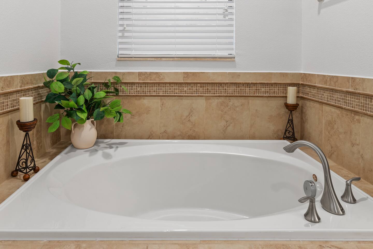 The garden soaking tub, framed in travertine with candlelight touches.