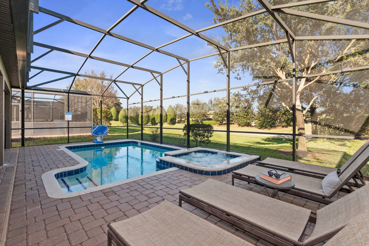 Sun-splashed pool deck and bubbling spa with open views of the green space.