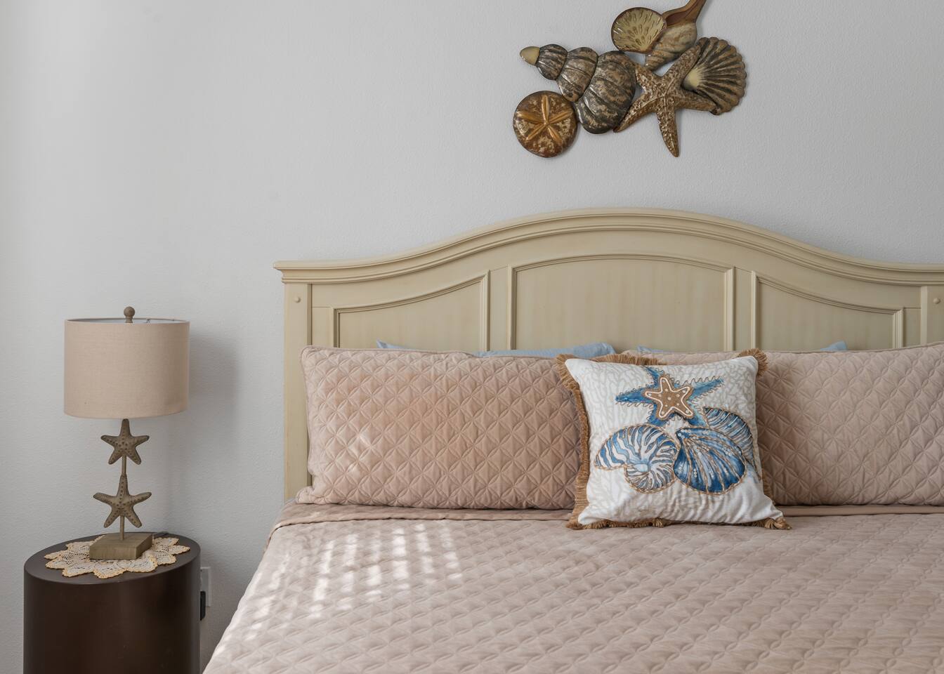 Shell art and starfish pillows finish the coastal king suite.