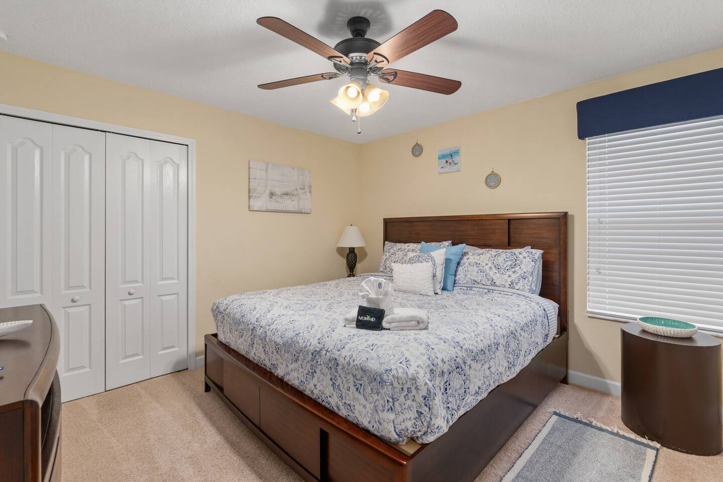 Beach king room in blue and white with storage bed and coastal art.