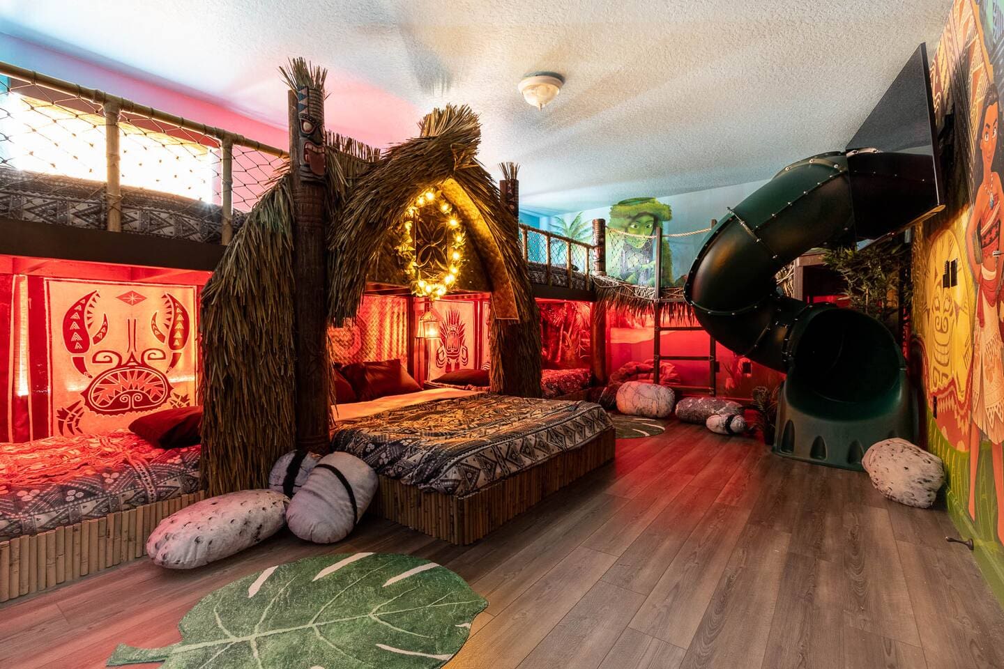 Moana-themed suite with a thatched-hut bed, tiki carvings, glowing wreath headbo