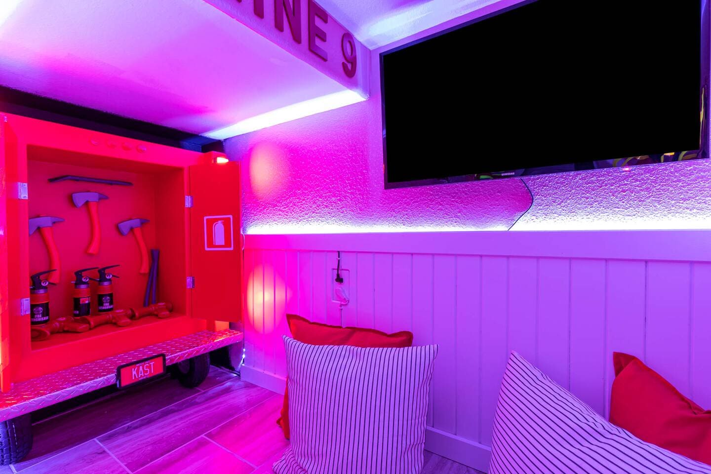 Inside the fire-station playroom: play fire-truck cabinet with toy axes and exti