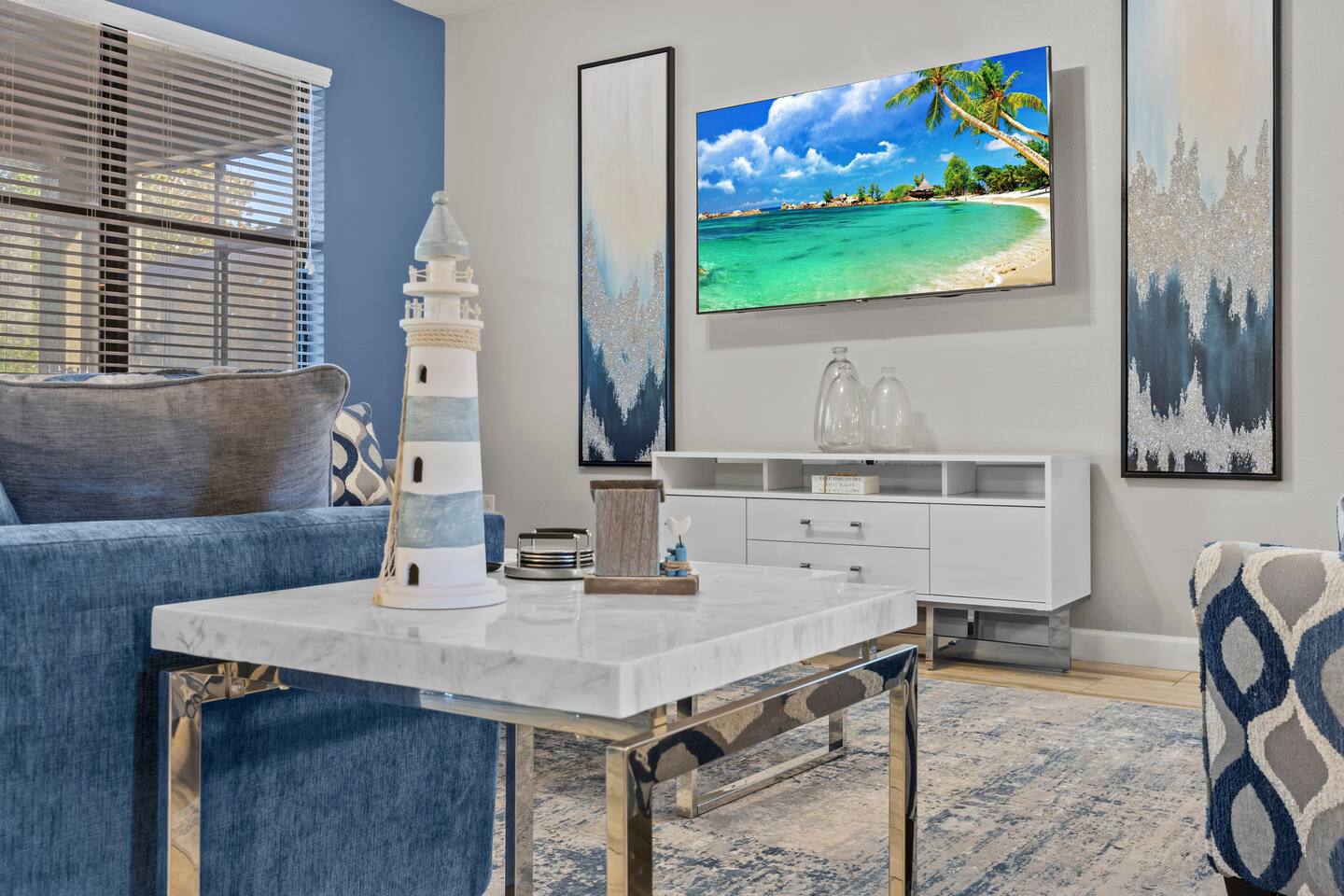 Living room detail with lighthouse decor on a marble side table and coastal artw