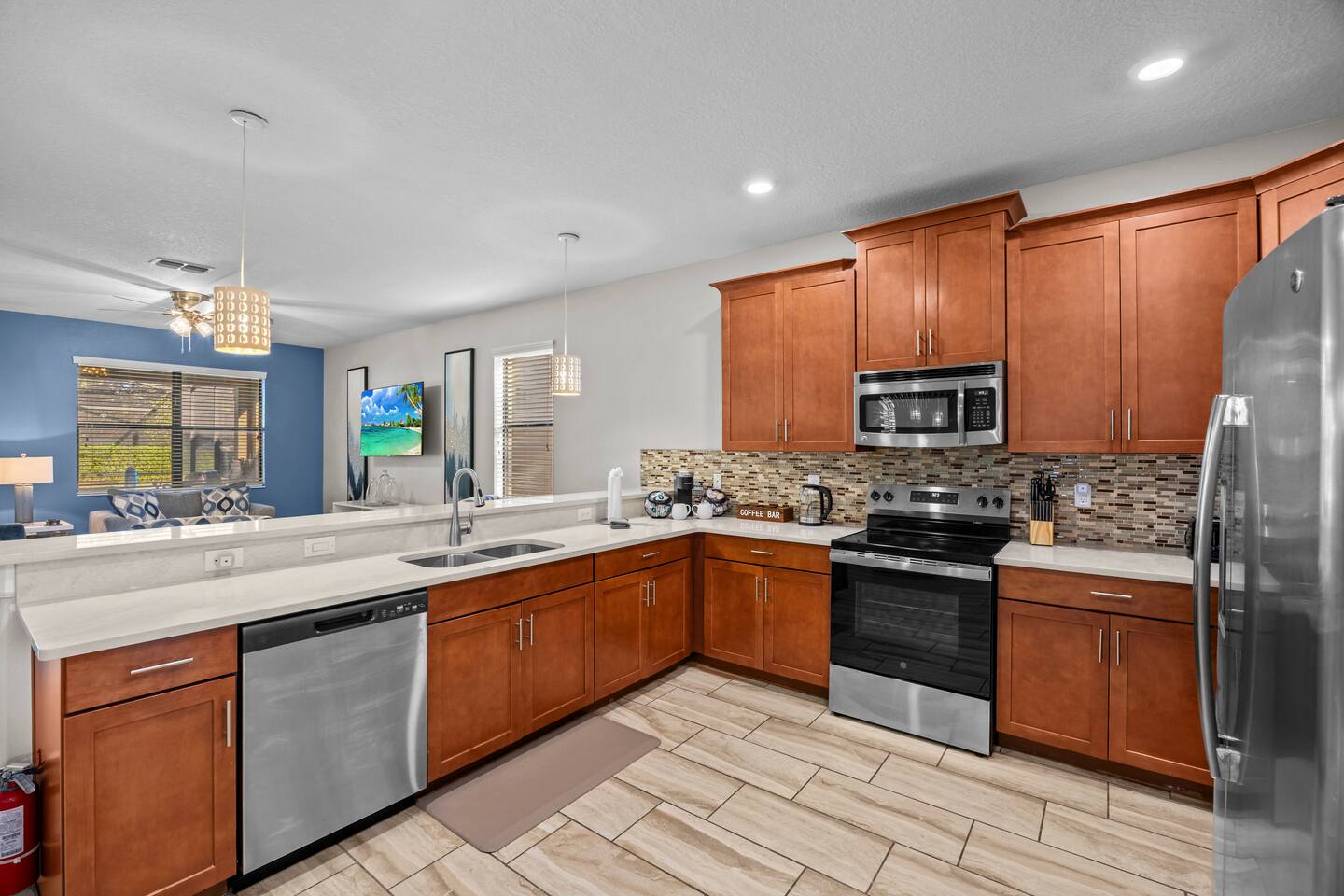 Kitchen work area with double sink, dishwasher, electric range, and view into th