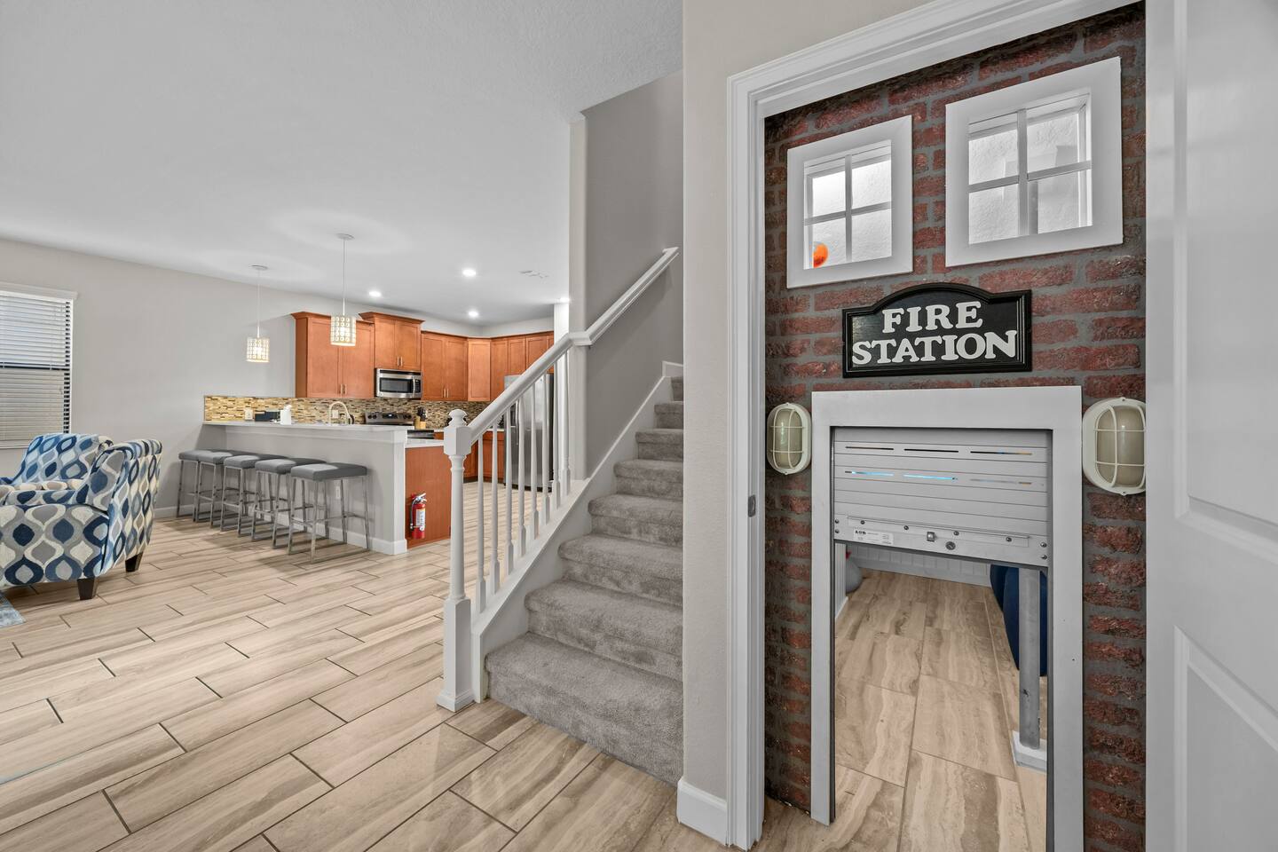 Staircase and entry hall with the fire-station playhouse door beside the kitchen