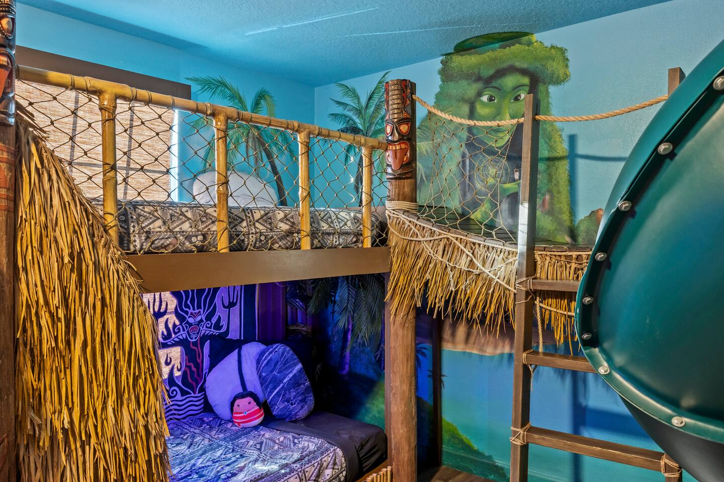 Bunk-bed corner of the Moana suite with netting rails, ladder, and island murals