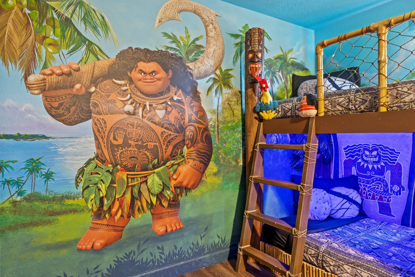 Close-up of the hand-painted Maui mural beside the bunk ladder with plush Hei He