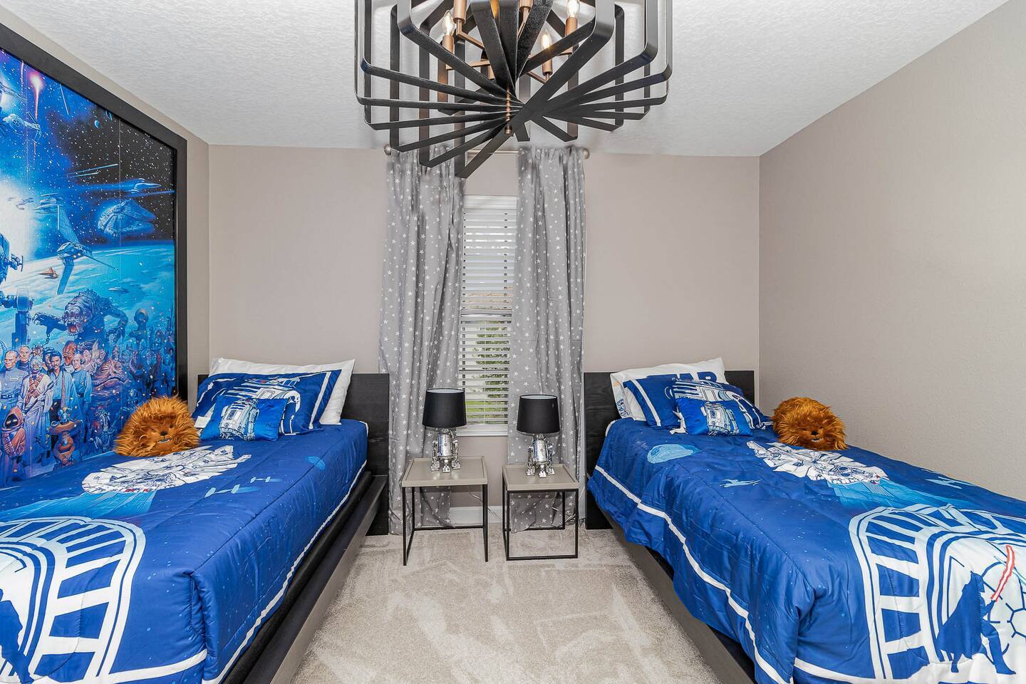 Star Wars bedroom with two twin beds, droid table lamps, and starfield curtains